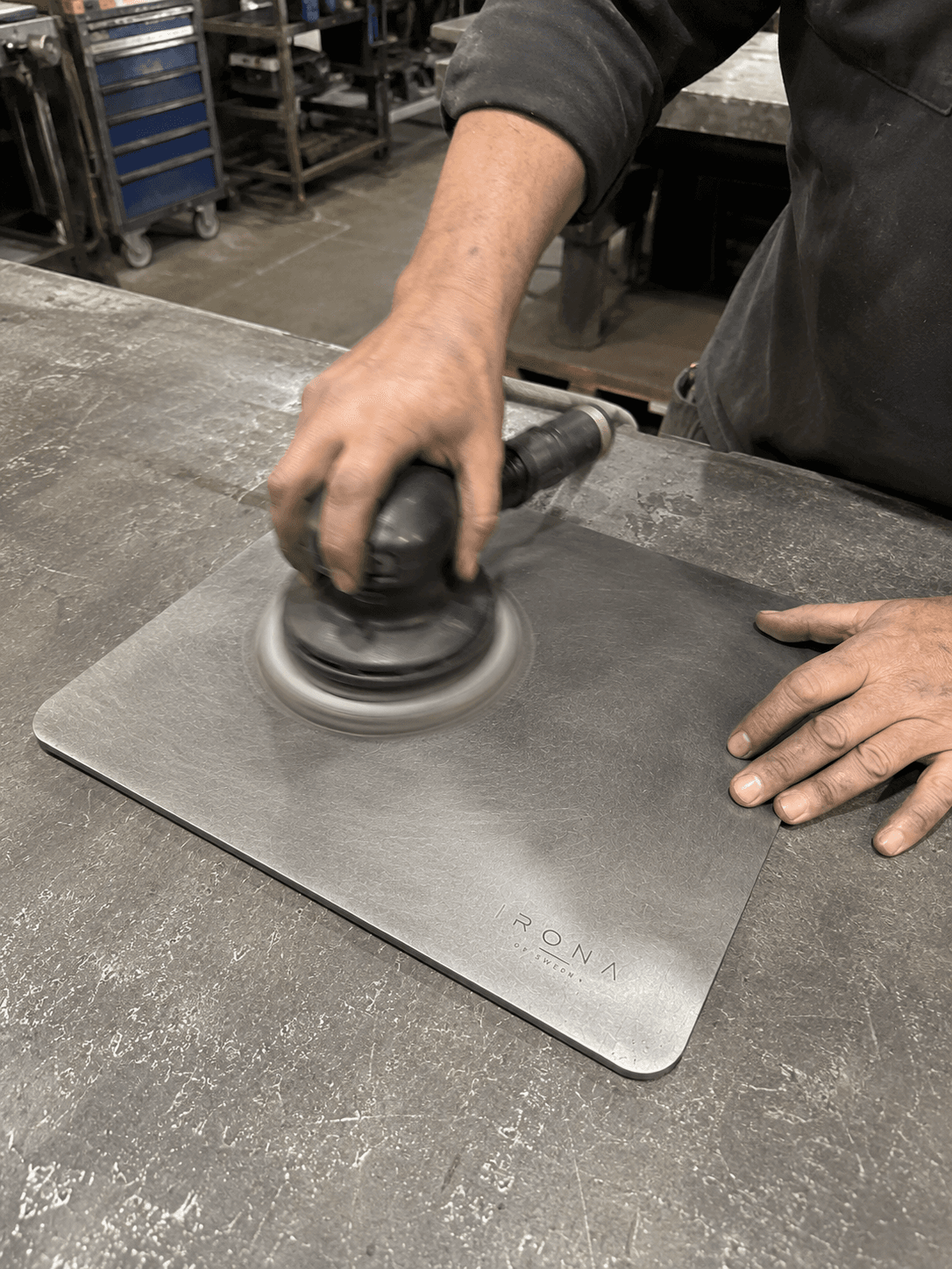 Hand-finishing an Irona 38 carbon steel baking plate with an orbital sander, Stockholm